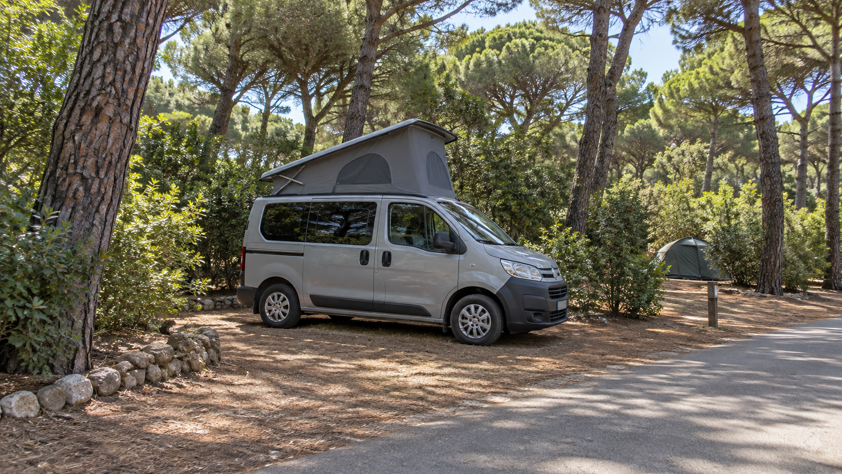 AI-gegenereerd algemeen sfeerbeeld met kleine hefdakcamper en groene beplanting; geen foto van Capannino Camping Village.